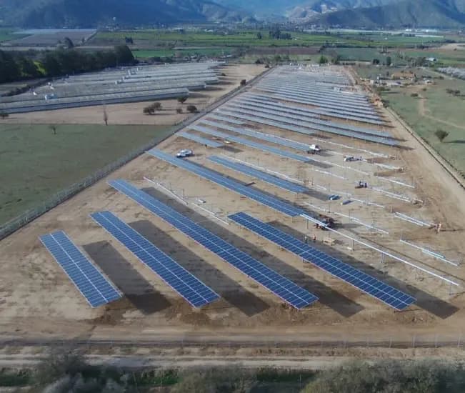 Vista aérea de una planta fotovoltaica en etapa de montaje de estructuras y módulos